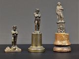trois figurines en bronze représentant un homme et une femme, posées sur un socle
