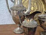 three silver vases sitting on a table next to a plate