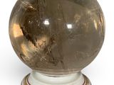 a crystal ball sitting on a pedestal on a white surface