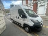 La petite camionnette blanche est garée sur le bord de la rue.