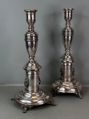 pair of silver plated candlesticks on stand on grey background