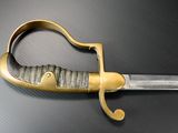 a close up of a sword on a table with a black background