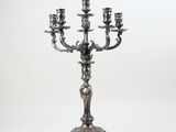a silver candelab with three candles on a stand