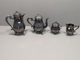 three pieces of silver tea and coffee set on a table