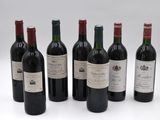 six bottles of wine are lined up in a row on a white surface