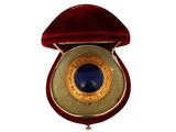 a red velvet case with a blue stone in it