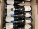 Les bouteilles de vin se trouvent dans un carton posé sur une table.