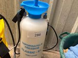 un vaporisateur bleu et blanc posé à côté d'un seau jaune et noir