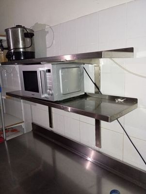 un micro-ondes posé sur une étagère dans une cuisine