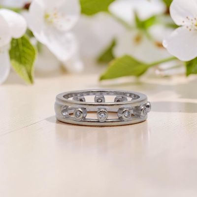 un gros plan d'une bague posée sur une table, avec des fleurs en arrière-plan