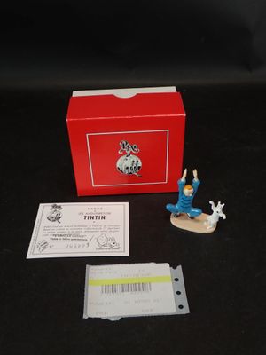 une petite figurine représentant un homme sur un skateboard devant une boîte rouge