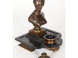 une image représentant un buste de femme en bronze posé sur un plateau