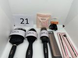 several hair brushes and combs sit on a shelf in a room