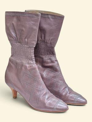 un gros plan sur une paire de bottes violettes sur fond blanc