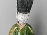two figurines of a man with a hat and a box