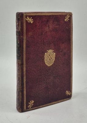 un vieux livre avec un emblème en or sur la couverture