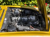 a close up of a yellow car with its hood open