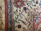 a rug with fringes on it on a wooden floor