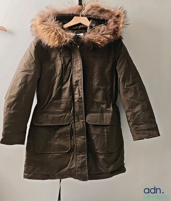 l'image d'un manteau suspendu à un cintre sur un mur