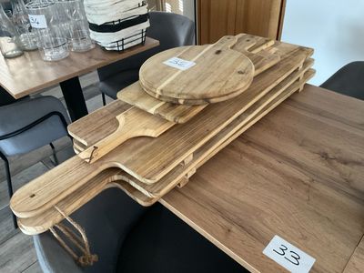 Plusieurs planches à découper en bois sont empilées sur une table