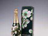 the bottle of champagne is next to the box on the table