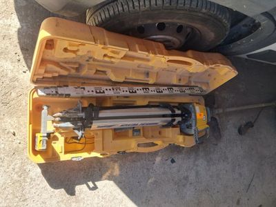 une boîte à outils jaune posée par terre, contenant des outils
