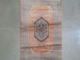 a rug hanging on the wall next to a pair of shoes