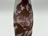 vase violet et blanc orné de fleurs, posé sur un fond blanc
