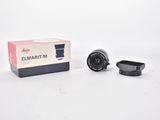 a close up of a camera lens and a box on a white surface