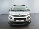 the front of a silver citrole parked in a white room