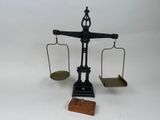 une image représentant une balance posée sur un bloc de bois