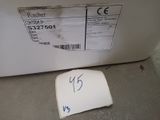 a label on a piece of paper on the floor next to a refrigerator