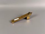 a gold tie bar sitting on a white surface