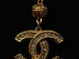 a gold necklace with a chanel logo on it