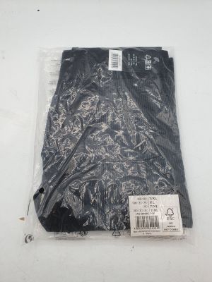 l'arrière d'un pantalon noir posé sur une surface blanche