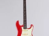 a red electric guitar hanging from a string on a white background