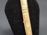 an image of a gold colored book on a black display stand