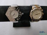two watches that are on display on a black stand