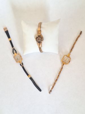 deux montres et un oreiller posés sur une surface blanche