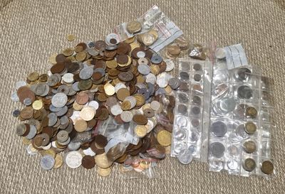 beaucoup de pièces de monnaie dans un récipient en plastique posé par terre