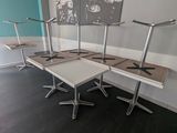 four tables with chairs in a room with a picture on the wall behind them