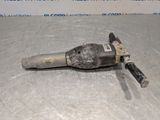 a close up of a drill on a metal surface with a sign in the background