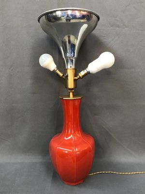 une photo d'une lampe en forme de vase rouge avec un pied en laiton