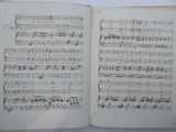 an open book with music notes on it sitting on a table