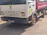 un camion blanc garé sur le bord de la route
