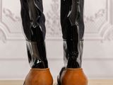 pair of black and brown boots with buckles on top of a wooden table