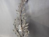 a metal sculpture of a leaf with a light bulb on it