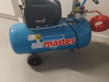 a blue air compressor sitting on the floor next to a wall