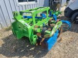 an image of a green tractor with a plow attached to it