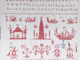 une broderie au point de croix rouge et blanche représentant une ville